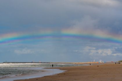 Regenboog boven het strand